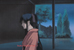 Kaoru stands quietly in a darkened doorway, waiting for a word from Kenshin.